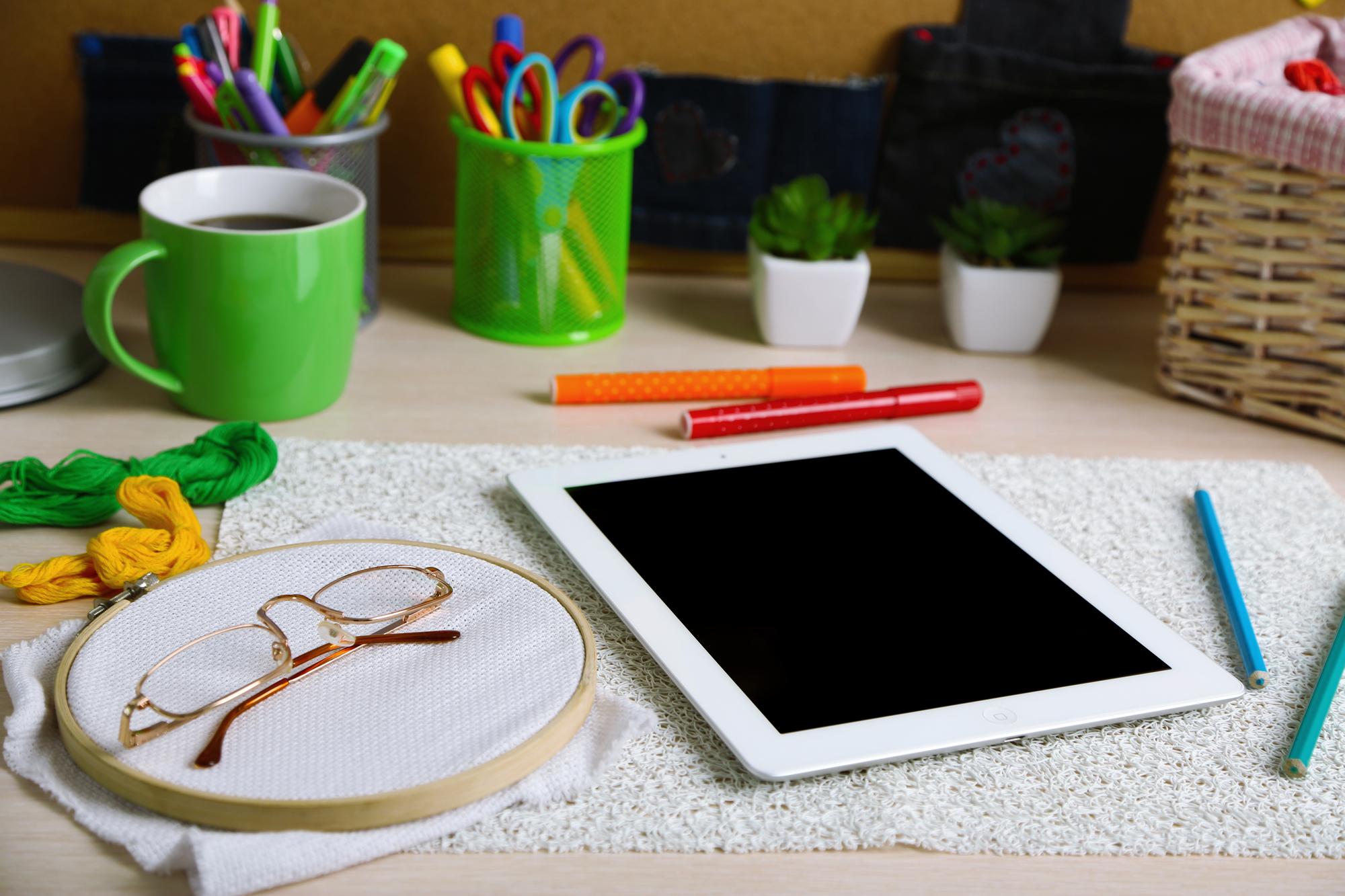Studio workspace with hoops, threads and a digitizing tablet